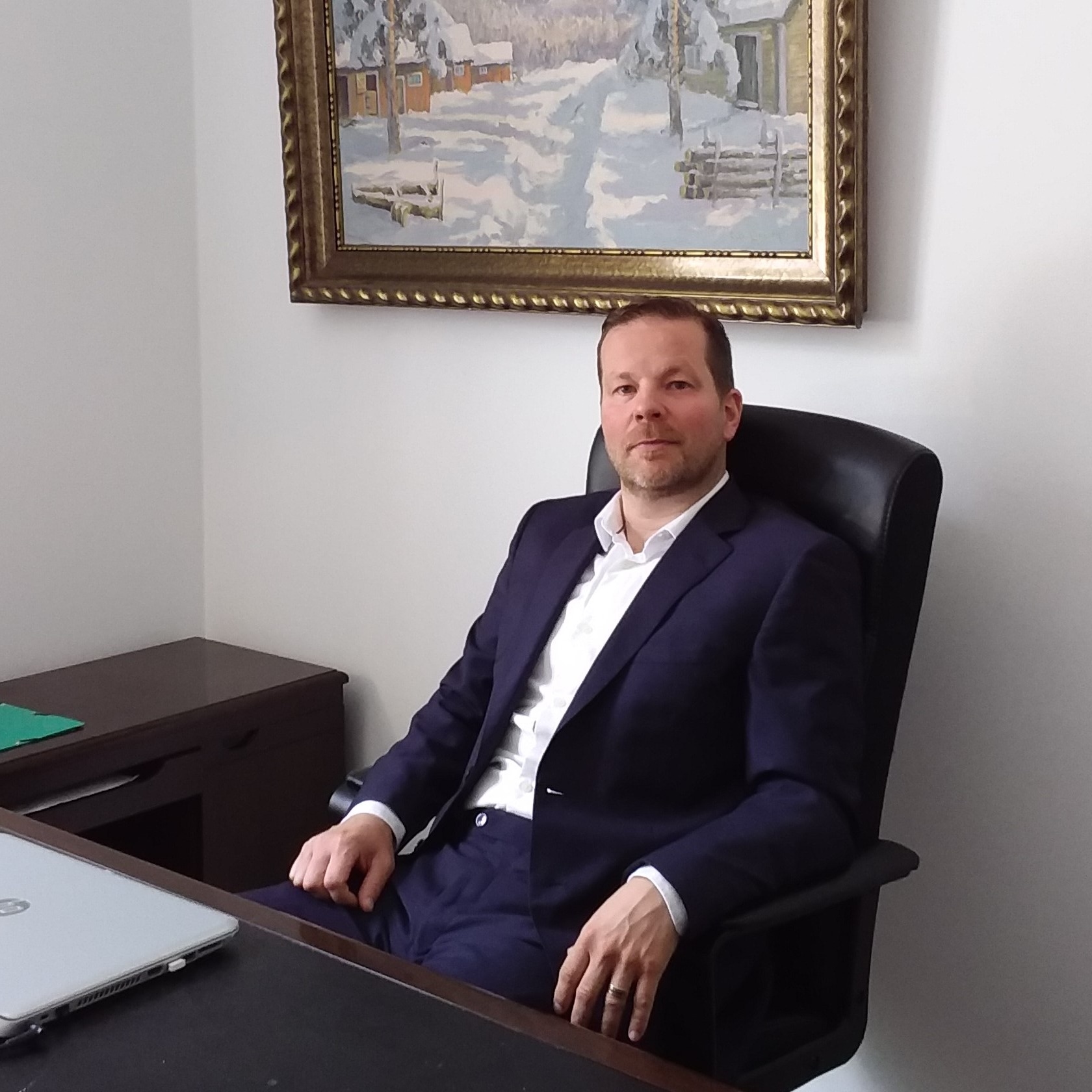 Per-Olov Martins Wedin vid ett ljust skrivbord med bok och anteckningsbok